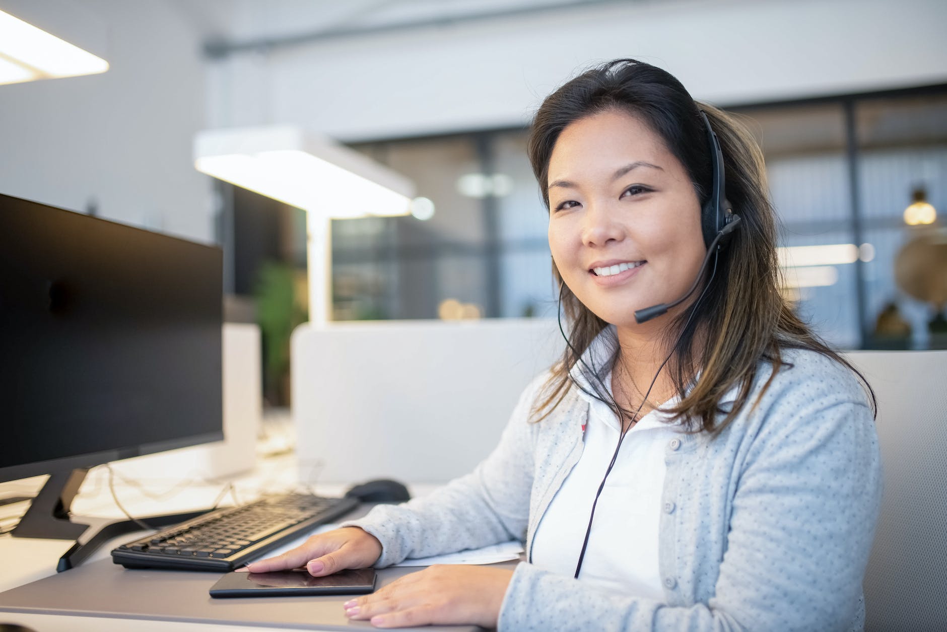 woman sitting behind a table working as call center agent