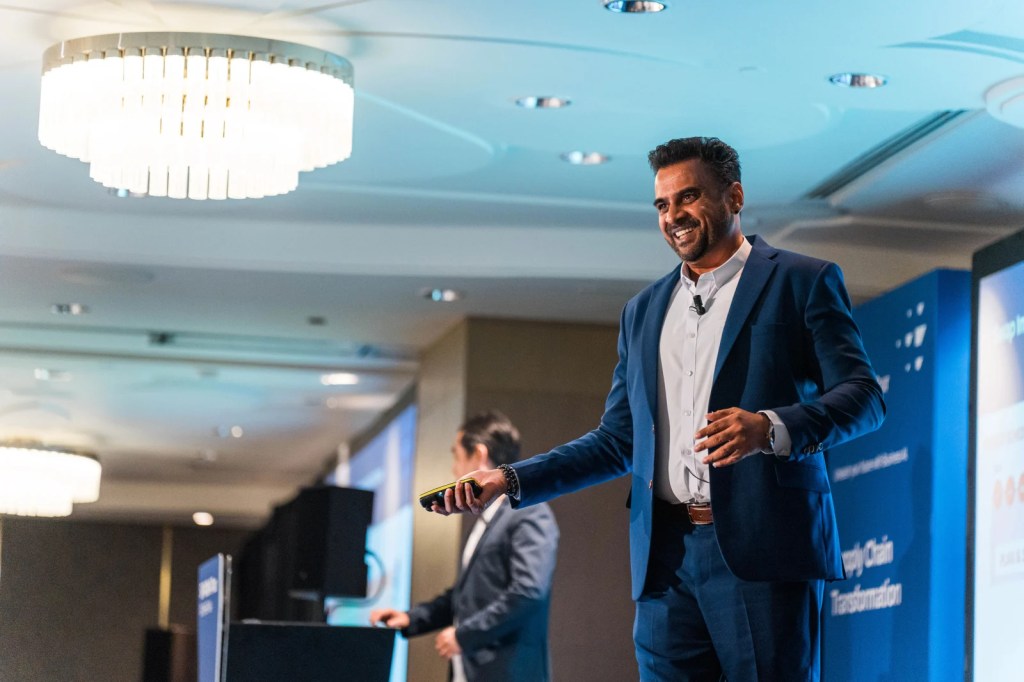 A speaker at the SAP NOW AI Tour in Singapore, engaging the audience with a presentation on digital transformation in supply chain management.